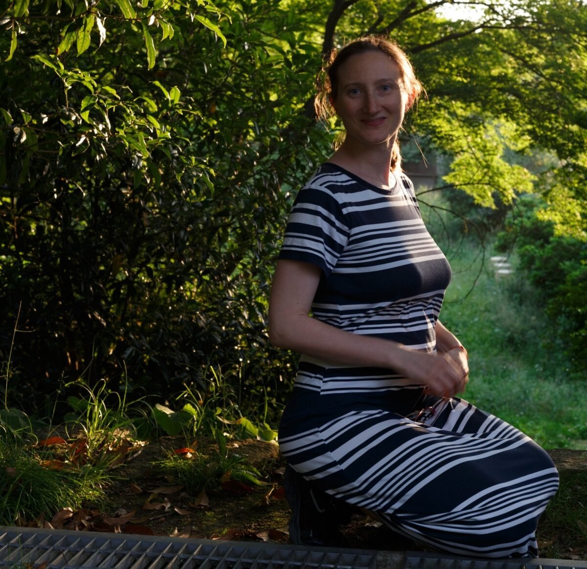 Pregnant woman sitting peacefully in nature, practicing prenatal mindfulness and connecting with her body before birth.