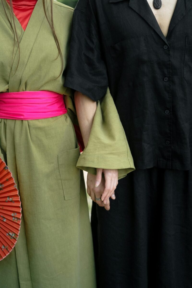 A couple in traditional Japanese attire holding hands, showcasing cultural aesthetics.