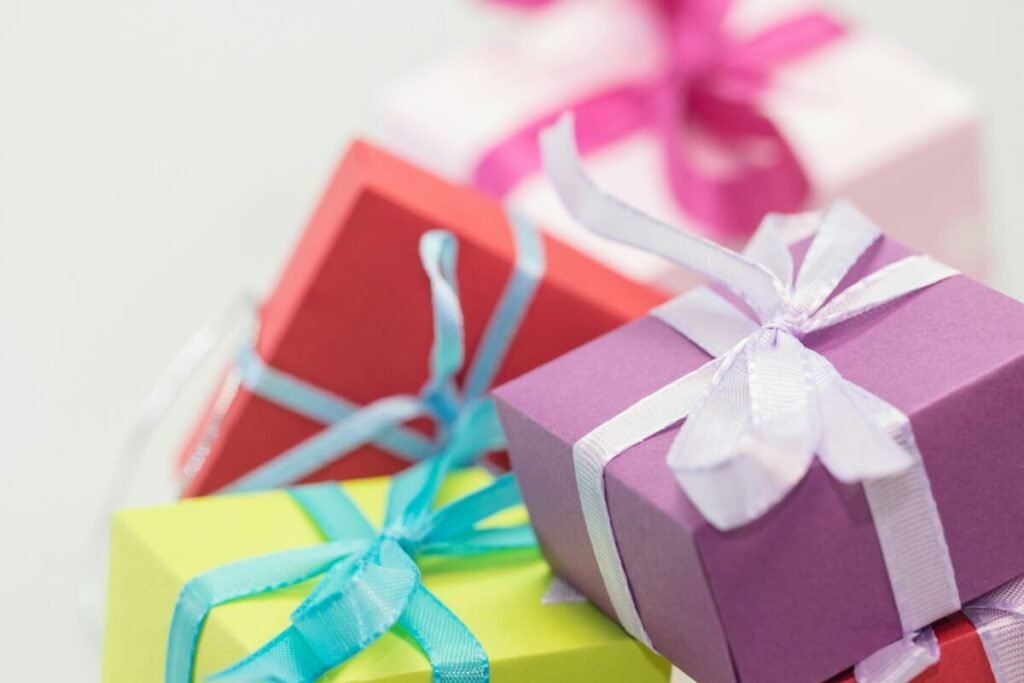 Close-up of vibrant gift boxes with ribbons symbolizing smart discount strategy how to combine referral rewards and coupons for maximum Aviva Method savings.